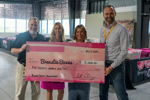 four people holding a large donation check for Breastie Boxes